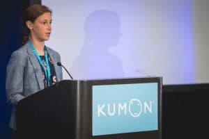 Ava speaks at the podium at the student conference