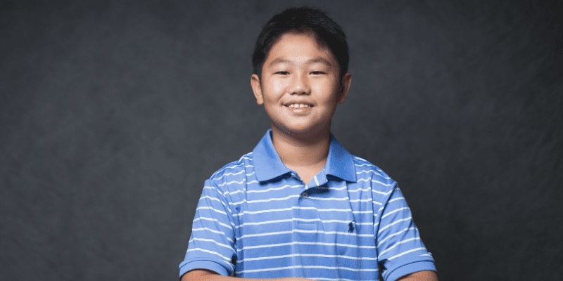 Gavin poses in front of a gray background