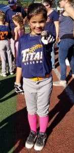 Jessica points her bat at the camera in her baseball uniform