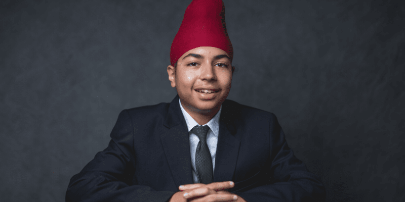 Hargoun poses in front of a gray background at the student conference