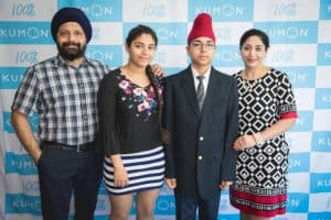 Hargoun poses with his family in front of a Kumon backdrop