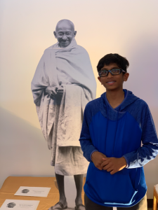 student standing next to a cut out of Mahatma Ghandi