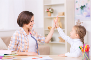 Mom gives daughter a high five in class