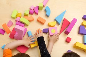 son and moms hands on top of colorful shapes