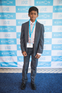 Kumon Student in front of the Kumon backdrop