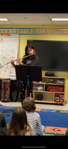 student standing at front of class playing her woodwind instrument