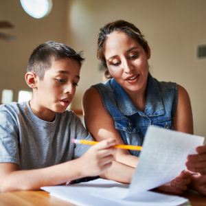 mother helping son with school work at home