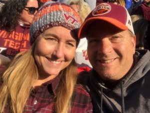 Nicole and her husband smile at a Virginia Tech game