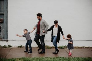 Son, father, mother, daughter holding hands walking to the left
