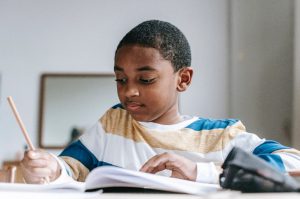 young boy working inside his workbook
