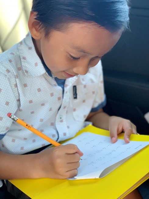 a young boy working on his math worksheet