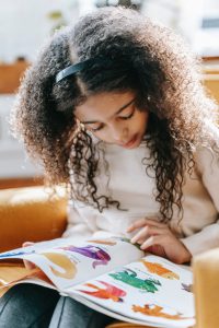 Young girl reading a book about animals