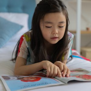 young girl reading while using her finger as a guide