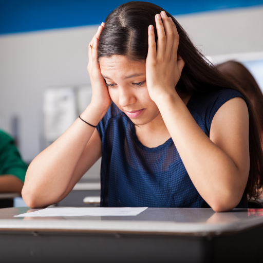 a student holding her head as a sign of Test Anxiety
