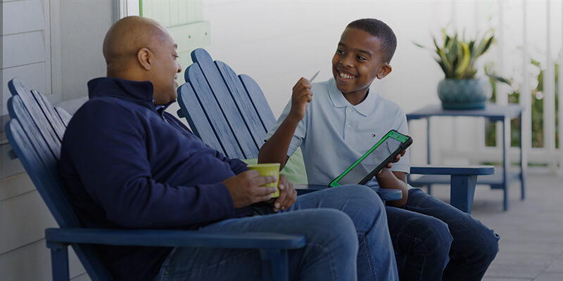 Son showing dad his work on a tablet