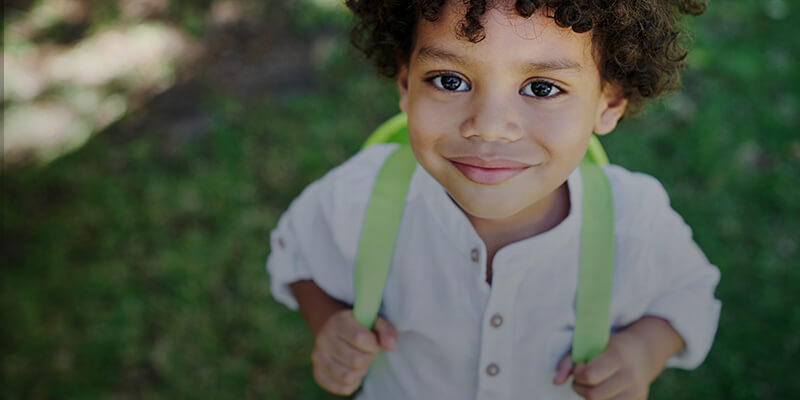 smiling child with book bag